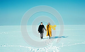 Happy walking couple. In love man and woman walking on the snowy ice. Winter vacation concept.