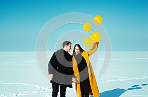 Happy walking couple. In love man and woman walking on the snowy ice. Winter vacation concept.