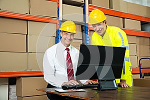 Happy Warehouse Worker And Manager Using Computer