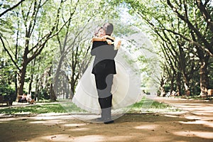 Happy wedding couple charming groom and perfect bride posing in park