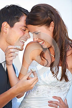 Happy, wedding and couple eating cake together for celebration of love together at party. Smile, cute and young bride