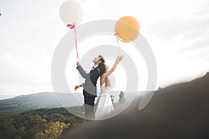 Happy wedding couple kissing and hugging near a high cliff