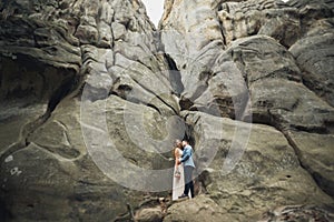 Happy wedding couple kissing and hugging near a high cliff