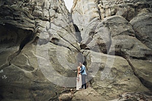 Happy wedding couple kissing and hugging near a high cliff