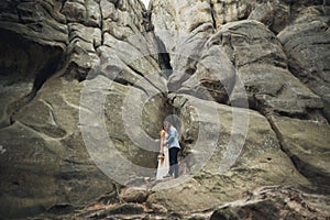 Happy wedding couple kissing and hugging near a high cliff