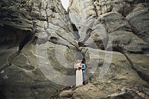 Happy wedding couple kissing and hugging near a high cliff