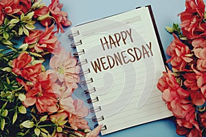 Happy Wednesday typography text on paper notebook flat lay on blue background