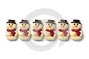 Happy white chocolate snowmen in a row on white background