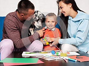 happy white family is happy and playing at home with a Dalmatian dog