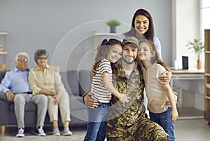 Happy wife and children hugging their veteran dad who came back from the military