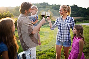 Happy wine grower family walking in vineyard