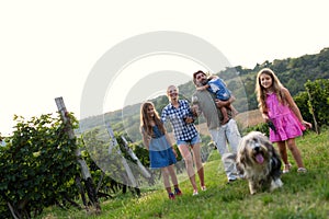 Happy wine grower family walking in vineyard