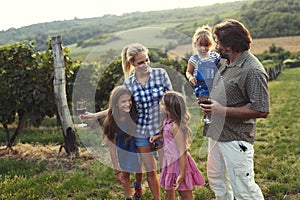 Happy wine grower family walking in vineyard