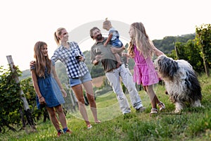 Happy wine grower family walking in vineyard