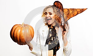 Happy winking girl in witch hat with pumpkin. Halloween party. Smiling woman with Jack-o-lantern.