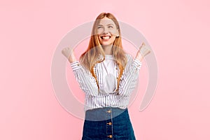 Happy Winner, happy young woman celebrating success isolated on pink background