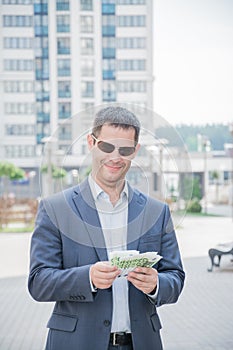 Happy winning business man holding his thumbs up with Euro money bills