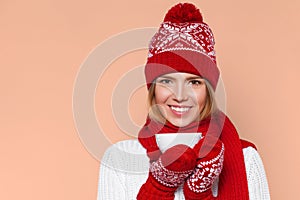 Happy winter girl in knitted warm hat and mittens holding a cup in hands. Smilling Christmas woman, isolated