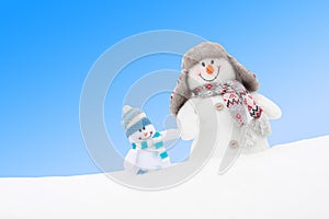 Happy winter snowmen family or friends against blue sky