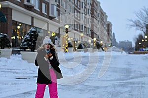 Happy winter time in city of charming girl walking on street enjoying cheerful mood
