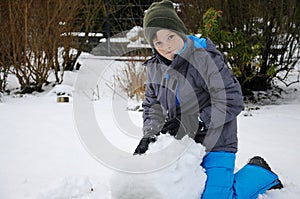 Happy wintertime, boy, plays outside in the snow