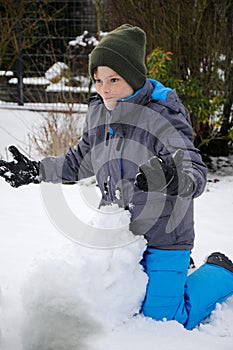 Happy wintertime, boy, plays outside in the snow