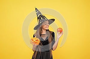 happy witch teenage girl with pumpkin jack o lantern wear costume of wizard on halloween party, halloween jack o lantern