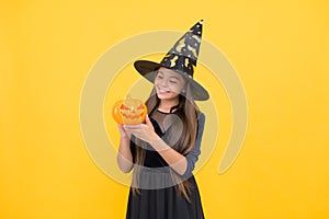 Happy witch teenage girl with pumpkin jack o lantern wear costume of wizard on halloween party, halloween pumpkin