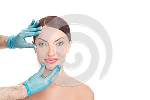 Happy woman after aesthetic surgery, smiles while the doctor shows the results. White background
