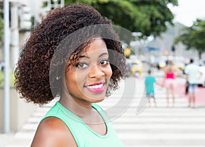 Happy woman from Africa in a green shirt in city