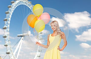 Happy woman with air balloons over ferris wheel