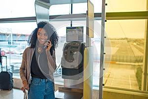 Happy Woman at the airport talking by public phone