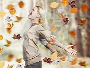 Happy Woman With Arms Outstretched Amid Fall Leaves photo