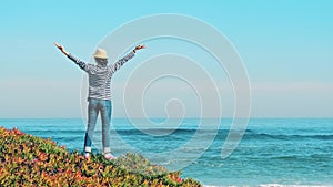 Happy woman with arms up on beach in summer. Happiness bliss freedom concept.