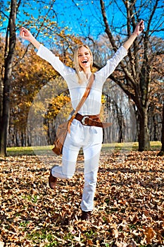 Happy woman in the autumn colored park .