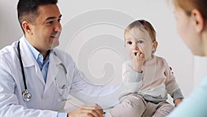 Happy woman with baby and doctor at clinic