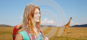 Happy woman with backpack over african savannah