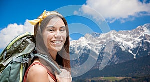 Happy woman with backpack over alps mountains