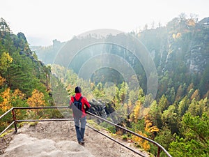 Happy woman with backpack stay on view point and shouting into vally