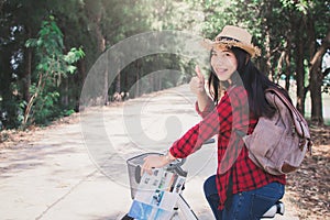 Happy woman backpacker with white bicycle in nature