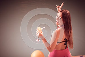 Happy woman with balloons and cocktail at poolside