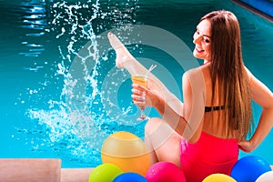 Happy woman with balloons and cocktail at poolside