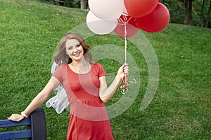 Happy woman with balloons in the park