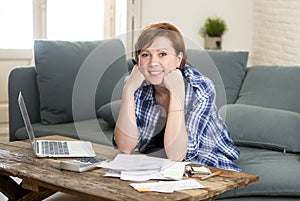 Happy woman banking and accounting home monthly and credit card expenses with computer laptop doing paperwork