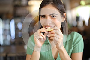 Happy woman in a bar biting lemon