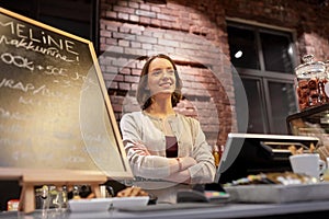 Happy woman or barmaid at cafe counter