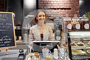 Happy woman or barmaid with cashbox at cafe