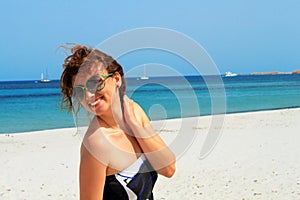Happy radiant young woman on the beach enjoying her summer holidays in Italy, Sardegna photo