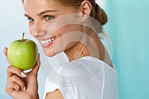 Happy Woman With Beautiful Smile, Healthy Teeth Holding Apple