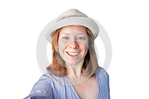 Happy woman with a beautiful smile makes a selfie, a tourist in a hat is photographed, isolated on a white background, travel